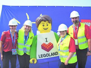 Workers from different LEGOLAND locales came out to the site for the first look at LEGOLAND New York in Goshen Thursday morning. From left are Jamie Winsper, Amy Kaeberle, LEGOLAND Man Mike, Rachele Rota, and Jeremy Pancoast.