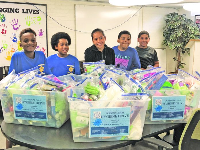 Youth members of the Middletown YMCA Leaders Club prepare hygiene kits at RECAP’s food pantry in Middletown.