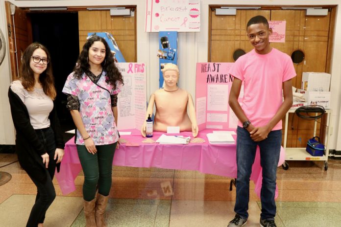 Mrs. Linda Romano, 2018 ACTE Teacher of the Year, and scholars in the Certified Nursing Assistant (CNA) are on a mission to educate their peers, teachers, and visitors to their high school building about the warning signs of Breast Cancer. In honor of Breast Cancer Awareness Month, the group of scholars set up in the lobby of Newburgh Free Academy, North campus to educate anyone who passed by.