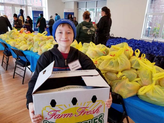 Logan Eisenberg, 12, of Middletown packages produce at RECAP’s Thanksgiving Drive distribution event.