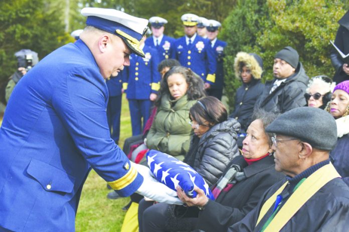 Rear Adm. Andrew Tiongson, commander First Coast Guard District, passes a folded American flag to a family member during funeral services for Dr. Olivia Hooker in White Plains, New York, Dec. 5, 2018. Dr. Hooker was the first African-American woman to enlist in the Coast Guard. Photo: Petty Officer 3rd Class Steve Strohmaier