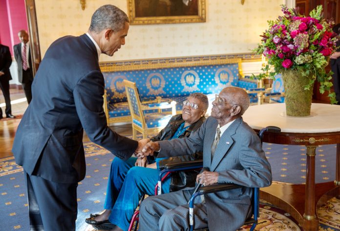 President Barack Obama greets Richard Overton, with Earlene Love-Karo, in the Blue Room of the White House, on November 11, 2013. Mr. Overton, was 107 at the time, and was the oldest living World War II veteran, attending the Veteran’s Day Breakfast at the White House. White House Photo: Lawrence Jackson