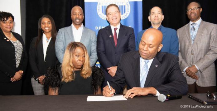 Lois Johnson, ceo and founder of of Salt Lake City, Utah-based United Security Financial (USF) and NAREB president Jeffrey Hicks(Front) sign the landmark $50 million agreement making down payment assistance funds available to expand homeownership opportunities for low and moderate-income Black American home purchasers. Witnessing the signing at NAREB’s Mid-Winter Conference in Miami, FL are: (2nd Row, L-R) Lydia Pope, NAREB 1st VP; Sumari Barnes, personal assistant to LJ Jennings; Tim Johnson, VP, Secondary Markets, USF; Michael Grant, regional president, USF; LJ Jennings, president, NAREB Sales Division affiliate, and Robert Hughes, chair, NAREB board of directors.