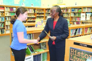 Ellenville Middle School student Braelyn Peavey receives her first place prize from Ellenville NAACP President Maude Bruce.