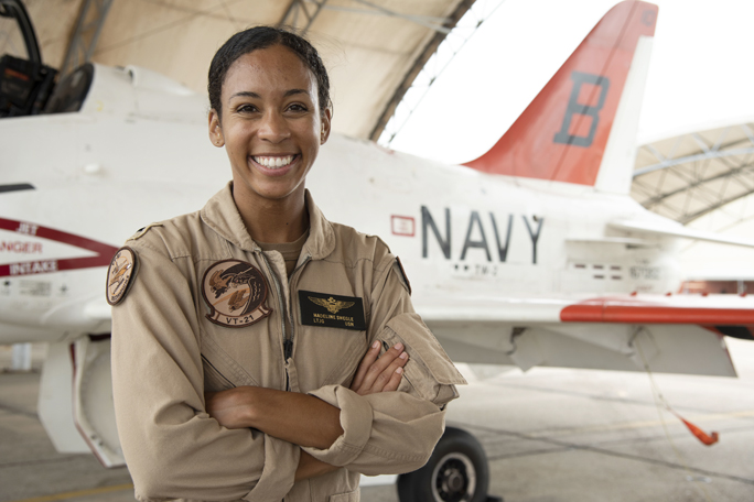 Lt. j.g. Madeline G. Swegle, the U.S. Navy's first Black female tactical jet aviator, stands in front of a T-45C Goshawk jet trainer aircraft on the Training Air Wing 2 flight line at Naval Air Station Kingsville, Texas, July 17, 2020. Swegle completed her final training flight with the 