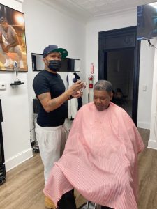 Moleek Murphy, owner of the newly opened barbershop, Krispy Fresh Cutz, applies some of his barber genius and many years of experience to a customer recently at the Broadway business.