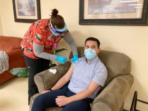 Nicole Harris (left), an LPN Clinical Coordinator at Cornerstone Family Healthcare, gives Enrique Bullon, a Medical Interpreter at the facility, one of the initial doses of the Moderna COVID-19 vaccine last Wednesday.