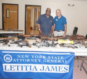 Rev. Jesse Bottom and NYS Assemblyman Jonathan Jacobson in front of the 79 firearms that were turned in to law enforcement at a gun buyback event hosted by the NY Attorney General and the Poughkeepsie City Police Department on Saturday, June 26, 2021. HUDSON VALLEY PRESS/ Chuck Stewart, Jr.