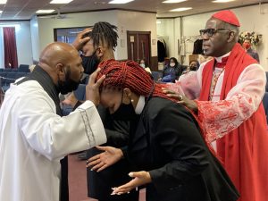 Pastor Hill lays hands on newly ordained Minister Sanders and Minister Hill with Apostle Woody.