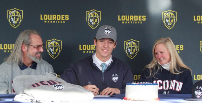 Lourdes senior, Ryan VanDeWater, signs his National Letter of Intent to play Baseball at UConn, while his father and mother, Marcus and Erika VanDeWater watch.