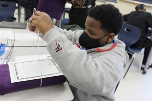 Sixth grader Maykel Wright ties a handwritten note to his blanket.
