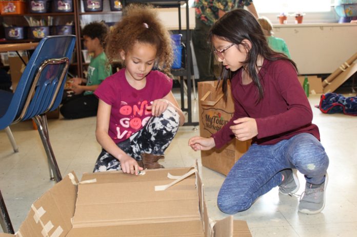 Grade 3 students Aliana Clark (left) and Valeria Castro-Linares take to problem solving during a recent STEM lesson in which they built roller coasters.