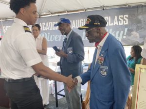 Mya Coley, one of the graduates of the RedTail Flight Academy, shakes hands with original Tuskegee Airman, Lieutenant Colonel Enoch Woodhouse (Ret.)