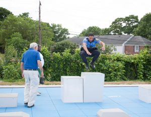 Officer Peterson demonstrates proper form for NYS Assemblyman Jonathan Jacobson on Thursday, June 7, as a new fitness court was dedicated in the City of Newburgh. HUDSON VALLEY PRESS/ Chuck Stewart, Jr.