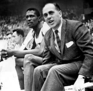 Russell with coach Red Auerbach in his rookie season, as they are seated on the sidelines. Auerbach refused to have a color barrier for the Celtics. Following his retirement in 1966, he handed off coaching duties to Russell as a player-coach. Photo: Wikicommons/Jack O’Connel