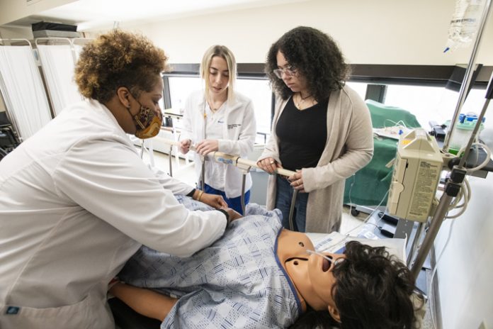 Mount Saint Mary College Nursing instructor Sidoney Mullings works with Newburgh Free Academy PALS students. NFA student Thalia Santiago (right) observes. Photo: Lee Ferris