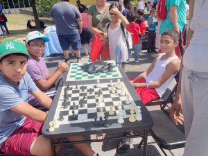 Youth take a break from playing chess at Saturday’s back- to- school event on Grand Street in the City of Newburgh.
