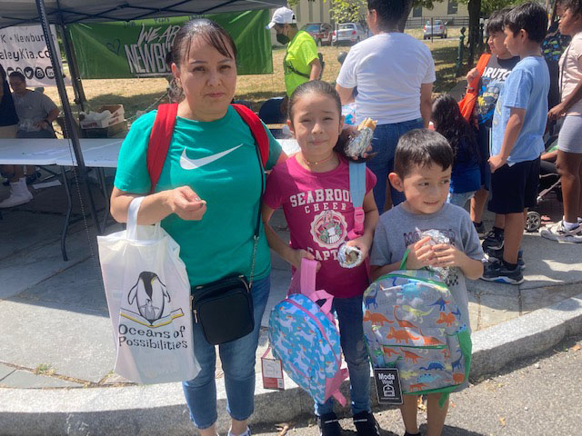 Mrs. Laureano and her daughter Evelyn, who is entering the third grade, and son Santiago who will be a first grader, show off their new back packs they received at the School is Cool: A Back to School Celebration on Saturday afternoon, held for Newburgh Enlarged City School District students to get them excited and feel supported by the community for the approaching school year.