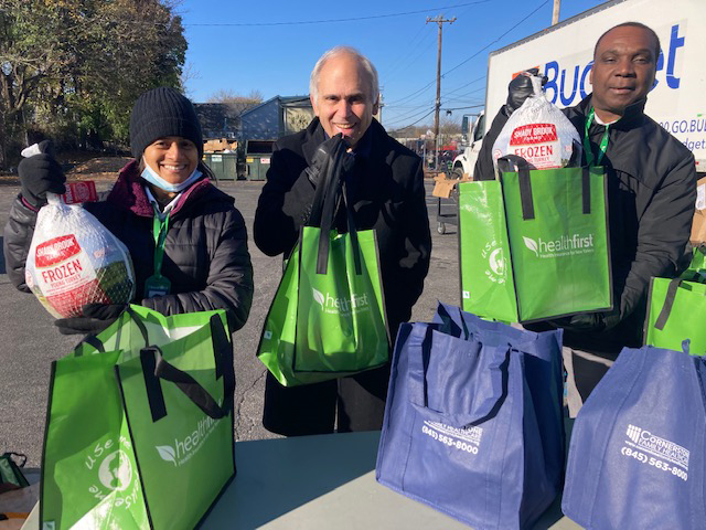 From left are; Lisbeth Hodge of Healthfirst, Assemblyman Jonathan Jacobson, and Yves Fignole-also a Healthfirst employee. The trio were handing out turkeys to community residents at Saturday’s Annual Loaves & Fishes event.