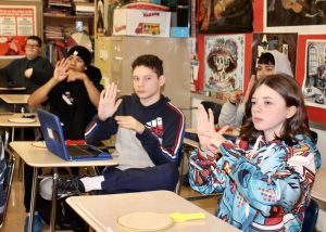 Grade 9 students (front to back) Shyanne Rahm, Martin Ortiz, Jason Collazo, C.J. Nelson, and Kenny Cruz (back) answer with the sign for “minus” in response to a question from their teacher Melissa Mourges during a new American Sign Language class at Wallkill Senior High School.