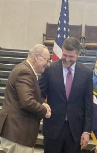 On right, Patrick Ryan, newly elected Senator, shakes hands with his long- time friend and mentor, Chuck Schumer, Senate Majority Leader, who swore him into office Sunday. 