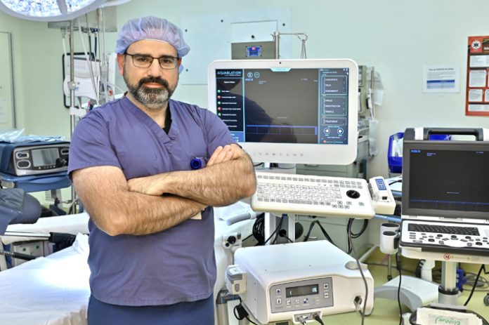 Mark Nogueira, MD, specialist in minimally invasive Urologic Oncology, Northern Westchester Hospital, stands in the OR next to the Aquablation® Therapy & Aquabeam® Robotic System. This non-invasive procedure is the next step to furthering Northwell’s commitment to robotic surgery and men’s health. The program began in January and there is a waiting list of those who can benefit from this advanced, non-invasive procedure.