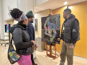 Local artist Auguster D. Williams, Jr. of PuzzlePieceArts (right) presented some of his artwork at Mount Saint Mary College. 