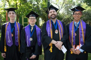 Four smiling graduates from the College’s Honors Program.