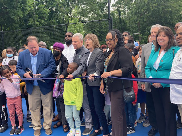 City of Poughkeepsie Mayor, Marc Nelson, flanked by local youth as well as several of the pivotal members involved in the Malcolm X Park’s official re-opening, cuts the ribbon of the thriving, long-awaited, much appreciated, new facility.