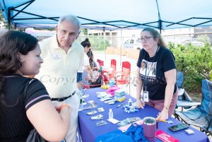 Annette Marzan, far right, and NYS Assemblyman Jonathan Jacobson speak with an attendee at the Planned Parenthood of Greater NY table at the Maternal Infant Services Network (MISN) free Community Block Party.  Hudson Valley Press/CHUCK STEWART, JR.