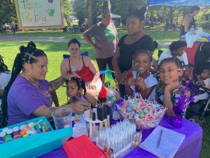 On left, Iris Florentino, Aunt of Tabitha Cruz, once again was on hand providing her face painting services while celebrating her beautiful, dearly- missed niece and doing all she can to bring community together in a positive way at Saturdays Annual Birthday Celebration for Omani & Tabby Day.
