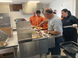 Volunteers- from sponsors, Vesuvio’s Ristorante and Papaleo’s Auto Body, at last Thursday’s 6th Annual Newburgh Community Thanksgiving Feast- are hard at work preparing meals for guests inside of the City of Newburgh’s Sacred Heart Parish Center.