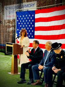 From left to right: County Clerk Kelly Eskew laughs as County Executive Neuhaus speaks to the audience. Seated next to Neuhaus are District Attorney Hoovler and Sheriff Arteta as Orange County hosted a Naturalization ceremony at the Newburgh Armory Unity Center.