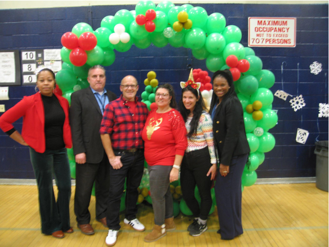Poughkeepsie Middle School staff members pose in front of decorations placed for the event.