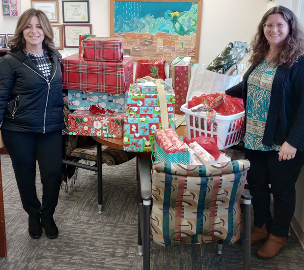 Danielle Moser, a Senior Public Health Educator with the Orange County Health Department (left), and Youth Bureau Director Rachel Wilson (right) with gifts for the County’s Adopt-a-Family program.