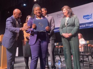 Florence Oyuko, one of 14 graduates of the inaugural cohort of the Dutchess Community College Direct Support Professional Microcredential, receives recognitions from college and other dignitaries.