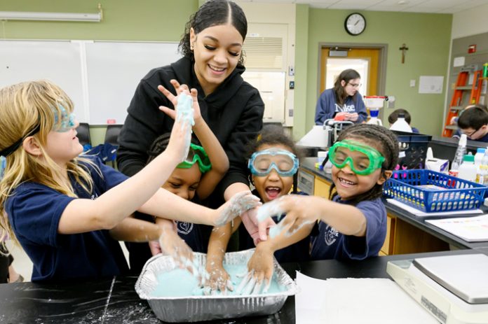 Iris Sanchez, a Mount Saint Mary College student, helps young scholars from Bishop Dunn Memorial School with science experiments. Photo: Lee Ferris