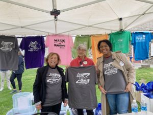 From left are Habitat for Humanity of Greater Newburgh volunteers; Cathy Maguire, Susan Smith, and Victoria Aleyakpo, flanked by some of the tee- shirts spanning the 25 years of the organization’s Annual Walks for Housing, with number 25 taking place Sunday.