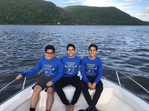 Christopher and Christian and their triplet brother, Jonathan, on the coach’s launch during rowing practice in their 8th-grade year. Jonathan will be attending College of the Holy Cross in the fall.  