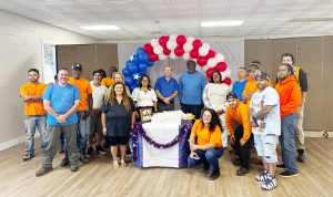 Superintendent of Public Works George Garrison (center) poses with family, friends, and coworkers at his surprise retirement party.