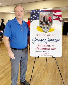 Superintendent of Public Works George Garrison poses for a photo at his surprise retirement party.