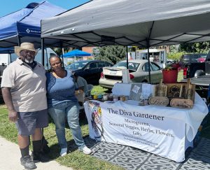 Spouses John and Terry Lassiter, co-owners of Diva Gardener, pose for a photo at the Healthy Orange Farmers Market.