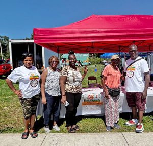 Bishop Jeffery C. Woody, pastor of The Cathedral at the House Church and organizer of the Healthy Orange Farmers Market, poses with church members.