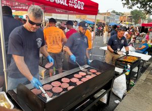 Firefighters cook hamburgers and chicken shish kabobs for the community.