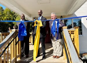 Pastor Ralph T. Cowan (center) cuts the ribbon and dedicates the brand-new Mount Triumphant Church of God along with Pastor Phil Johnson (left) and Councilman John Fraino (right).