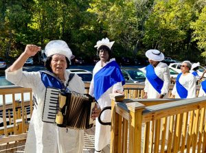 Mount Triumphant Church of God marches into their brand-new sanctuary led by Lady Prophetess Norma Cowan playing the accordion.