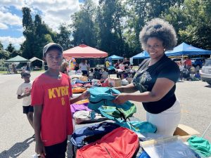 On right, Chloe Vita of Mid-Hudson Chocolate Milk, one of the sponsors for Saturday’s Back-to-School Community Resource Fair, hands Kyrie Degny, who will be entering sixth grade, a knapsack.