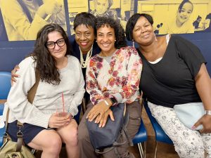 Superintendent Dr. Jackielyn Manning‑Campbell (2nd from left) poses for a photo with community members after the special school board meeting to re­instate her.