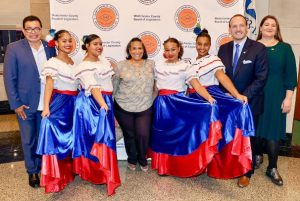 The evening began with the Dominican Cultural Association of Yonkers Dance Group joyfully performing two traditional folkloric dances on the chamber floor, their vibrant blue and red skirts flowing as they moved.