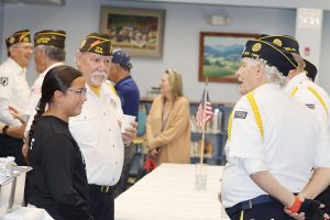 Saugerties Junior High Grade 7 student Sophia Martinez-Sosa enjoys a conversation with local members of the VFW before the Veterans Day Assembly. Photo: Jordyn Long
